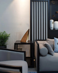 Modern triangular wood table lamp with warm light on black table in stylish living room, YH Lamps