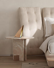 Modern triangular wood table lamp with warm light on marble nightstand in stylish bedroom