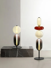 Modern glass table lamps with warm light and black bases on gray marble and floor, minimalist decor