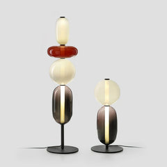 Modern table lamps with stacked oval candied glass shades in warm light on black metal bases