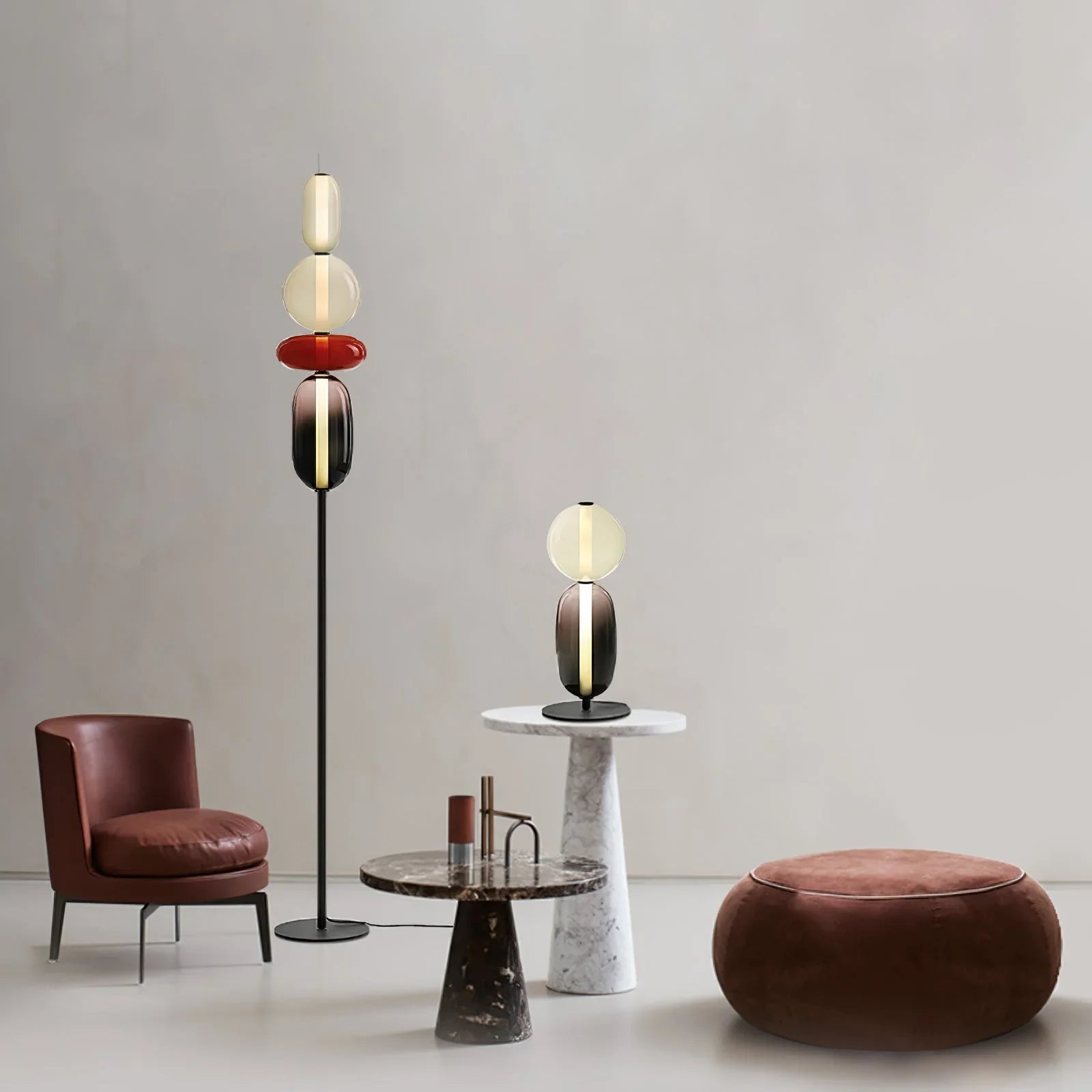 Modern living room with YH Lamps tall floor lamp and table lamp featuring colored glass blobs, leather chair, marble tables, and round pouf
