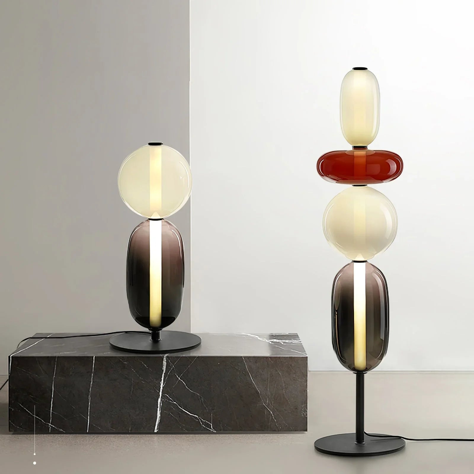 Modern decorative table lamps with stacked glass orbs in warm and smoked tones on black metal bases