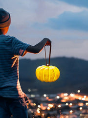 Person holding YH Lamps pumpkin-shaped yellow portable table lamp outdoors at dusk