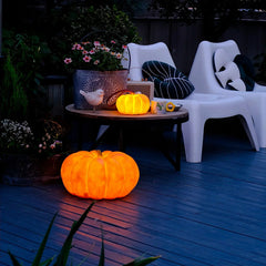Pumpkin-shaped yellow portable table lamp glowing outdoors on patio with modern decor by YH Lamps