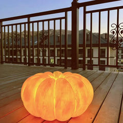 Portable yellow pumpkin table lamp glowing on a wooden balcony, modern home lighting by YH Lamps