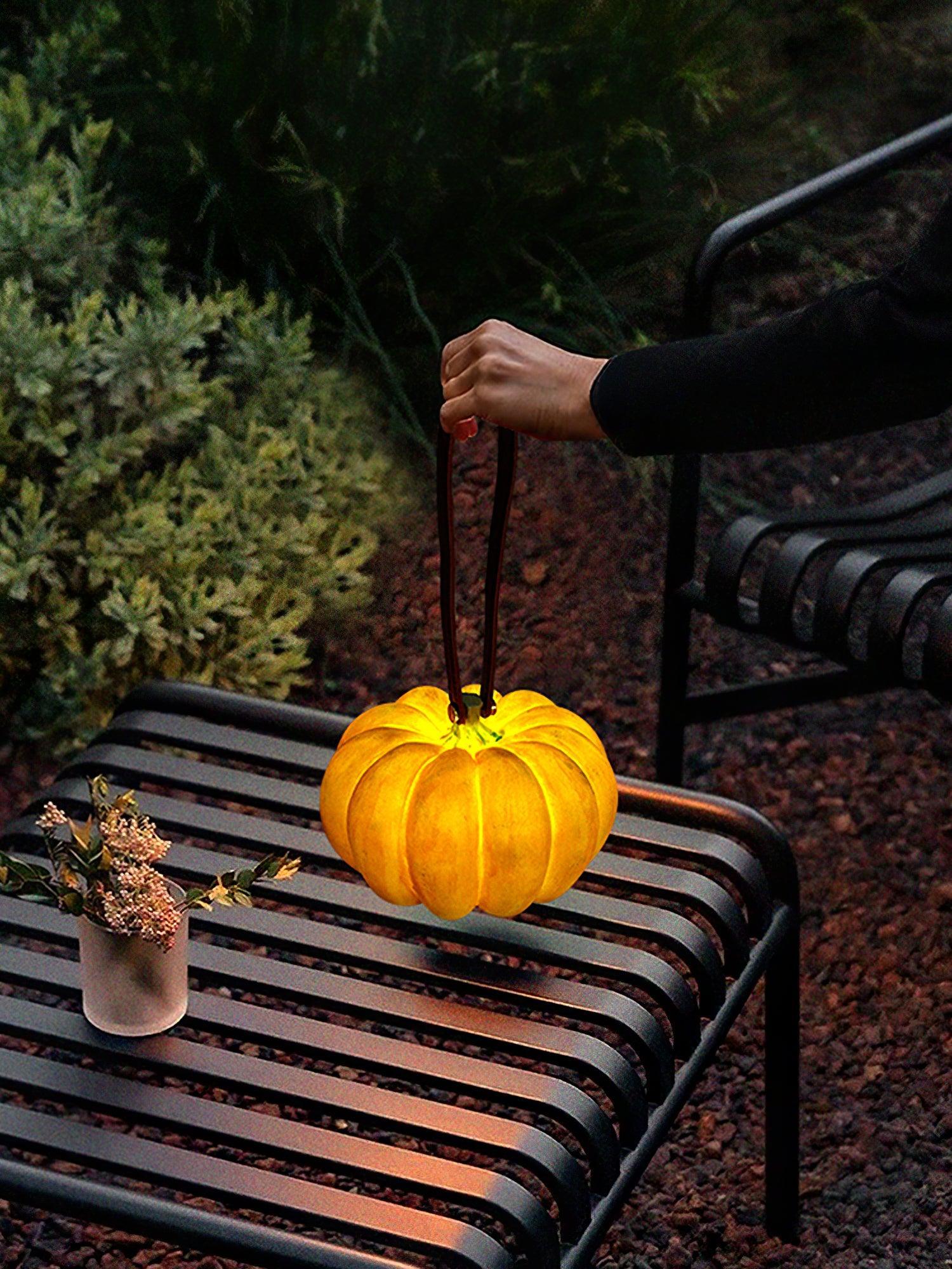 Yellow pumpkin-shaped portable table lamp with handle on outdoor bench, YH Lamps