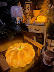 Glowing pumpkin-shaped portable table lamp on chair, cozy home decor, YH Lamps lighting design