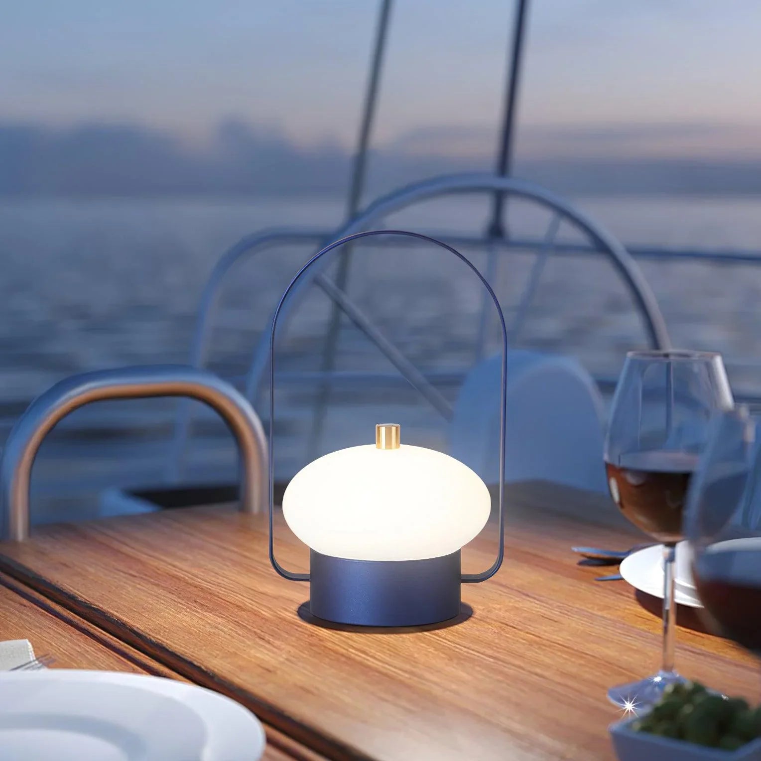 Modern dark red portable table lamp with soft glow on outdoor dining table, YH Lamps