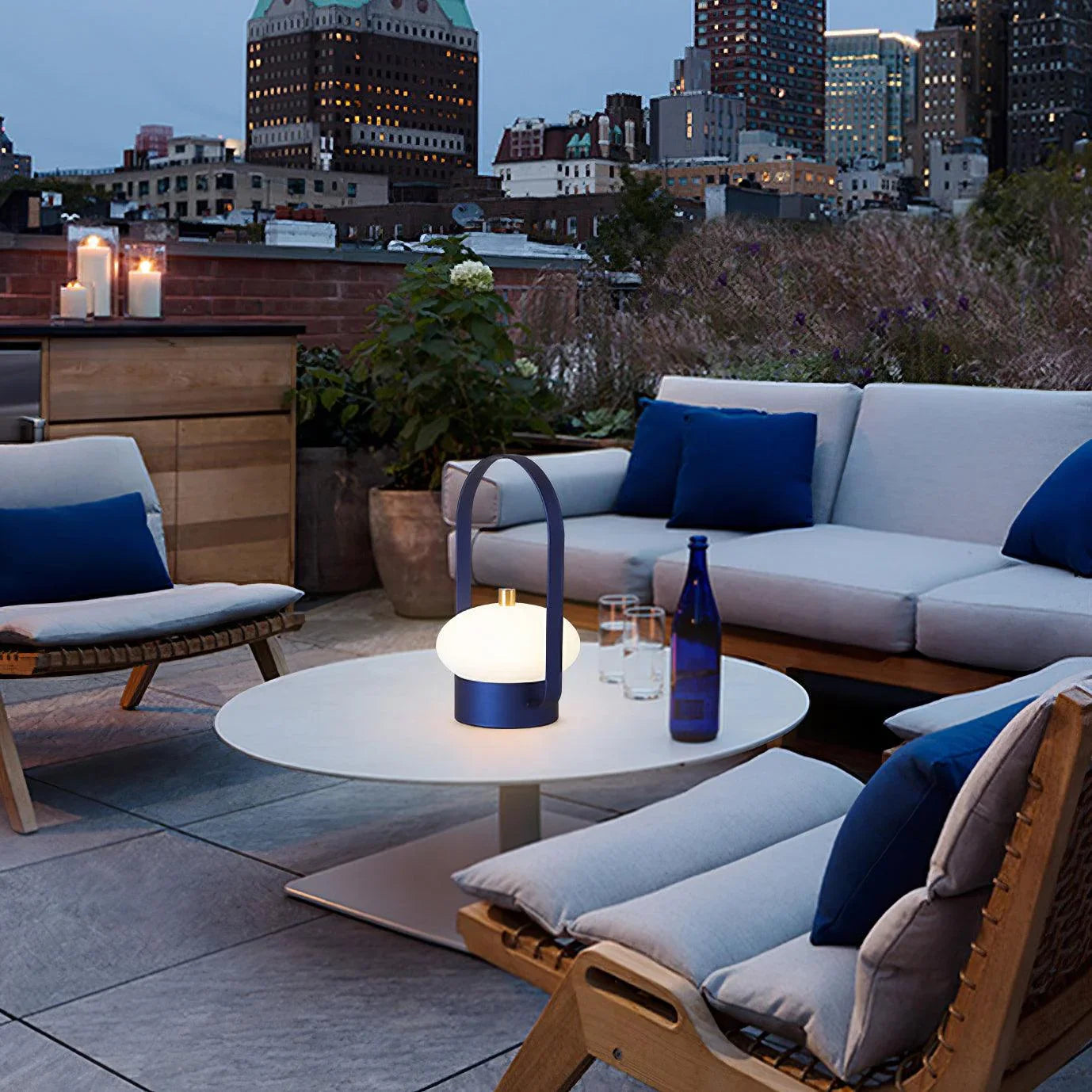 Modern dark red touch switch portable table lamp on outdoor patio table at dusk