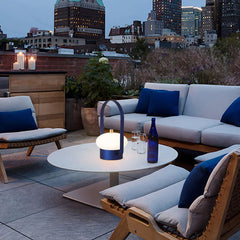 Modern dark red touch switch portable table lamp on outdoor patio table at dusk