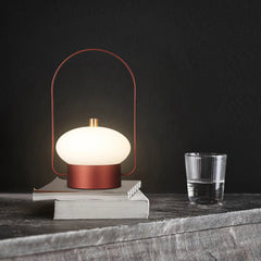 Modern dark red portable table lamp with soft white glow on stacked books, YH Lamps home decor