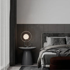 Modern designer double ring table lamp with globe bulb on bedside table in elegant bedroom