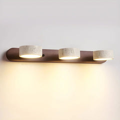 Modern 3-light wall lamp with walnut base and travertine-colored cylindrical shades emitting warm light
