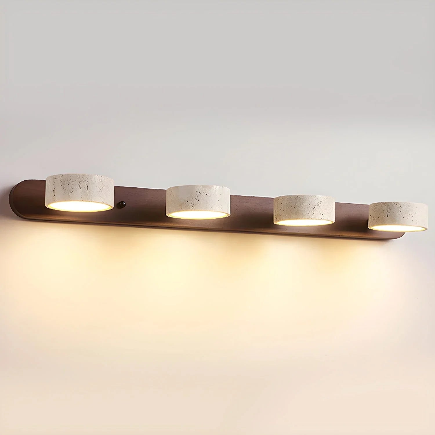 Modern four-light wall lamp with walnut finish and travertine shades emitting warm light