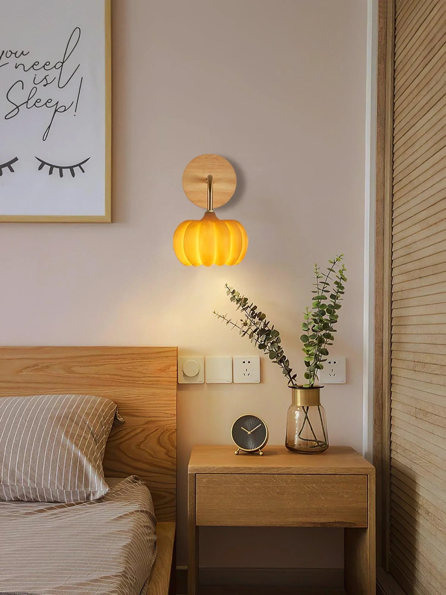 Yellow gold pumpkin-shaped wall lamp by YH Lamps above wooden nightstand in modern bedroom