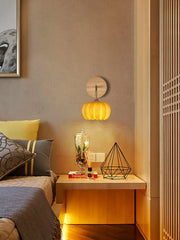 Yellow gold pumpkin wall lamp from YH Lamps mounted in a modern bedroom setting