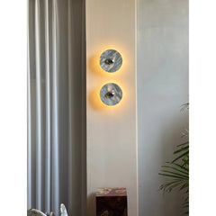 Modern round marble wall sconces with warm LED light in a contemporary living room setting