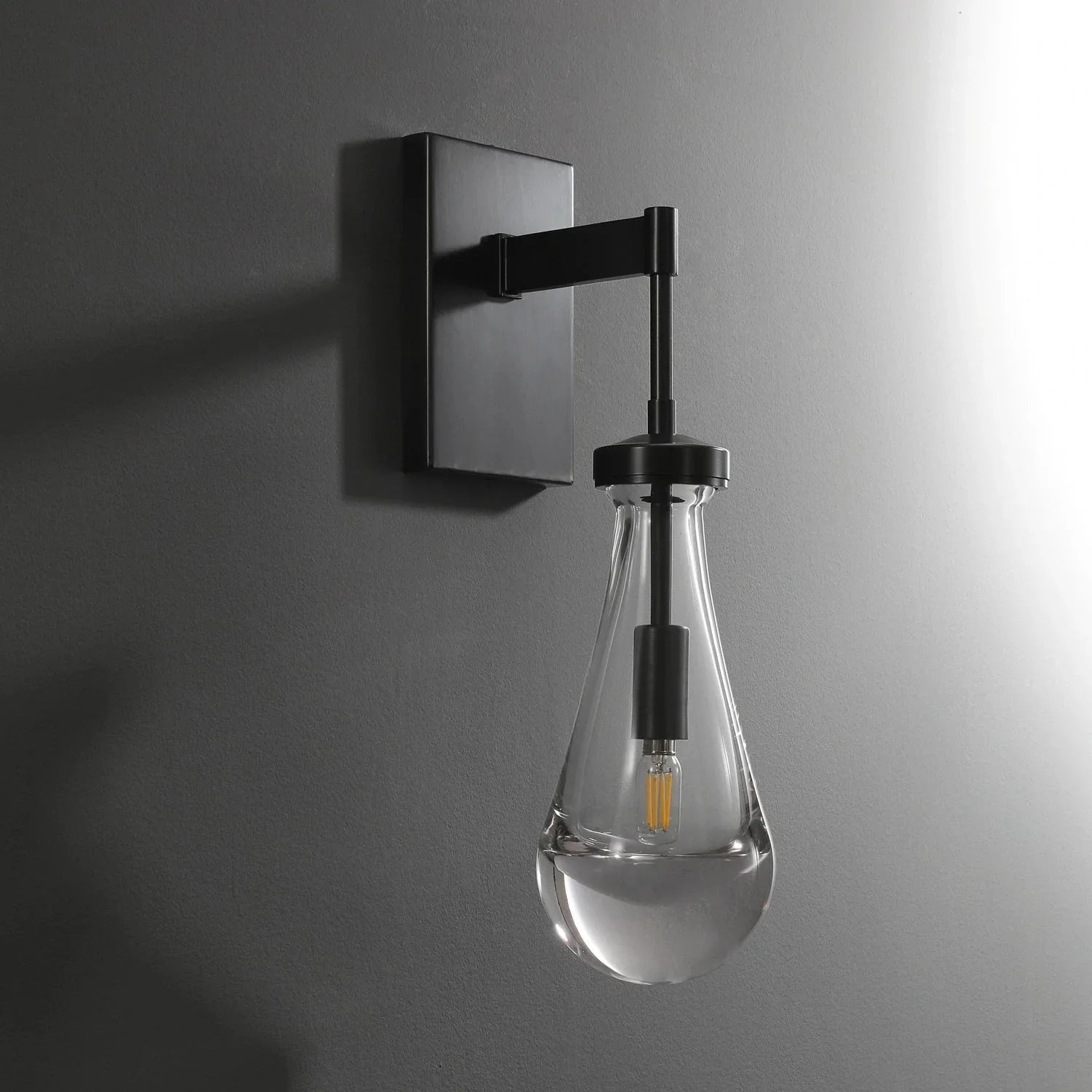 Modern raindrop glass wall sconce by YH Lamps mounted on a gray wall, elegant lighting design.
