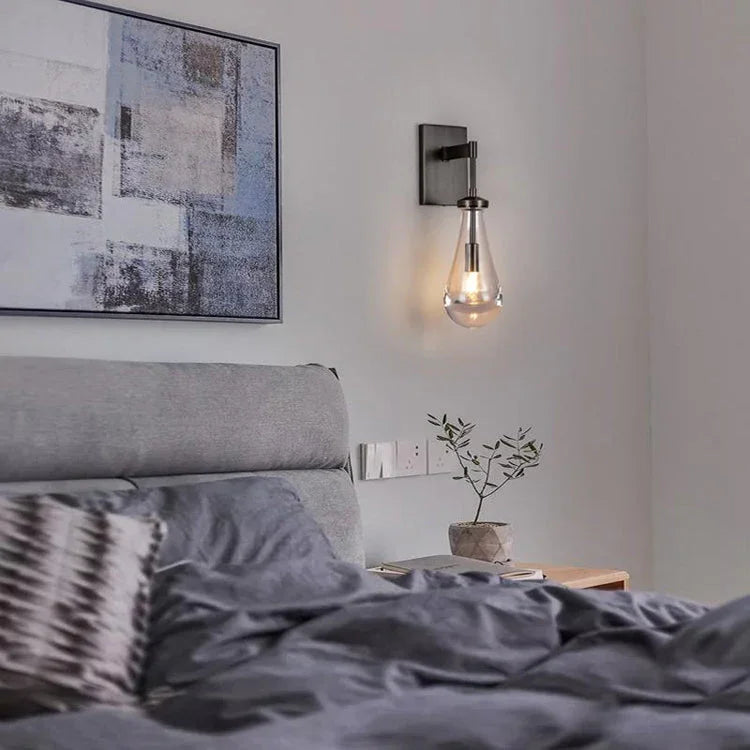 Modern raindrop wall sconce by YH Lamps above a grey bed in a stylish bedroom