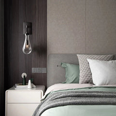 Modern raindrop wall sconce by YH Lamps in a stylish bedroom with soft bedding