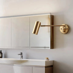 Modern gold swing arm wall sconce above bathroom sink with mirror and soap dispenser