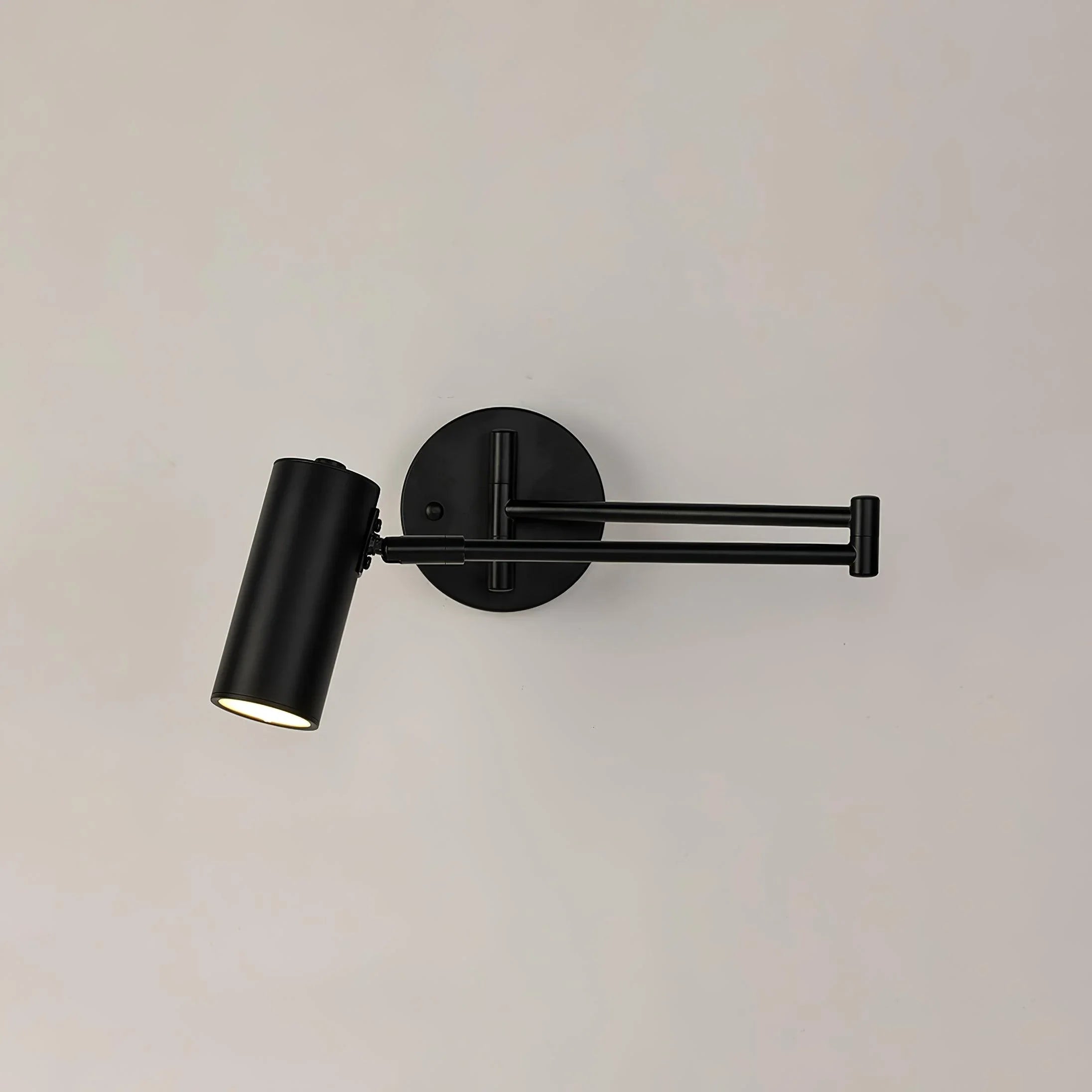 Modern black metal swing arm wall lamp with cylindrical head and warm light on beige background