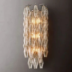 Modern Murano clear glass wall sconce with layered geometric design, lit on grey wall