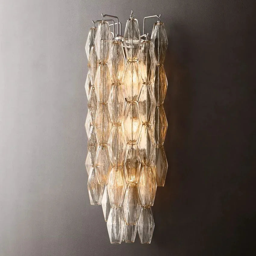 Modern Murano clear glass wall sconce with geometric panels, lit on a dark background at YH Lamps