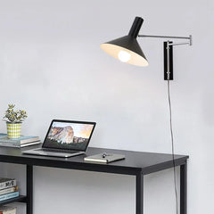 Modern black wall lamp with adjustable arm above minimalist desk workspace