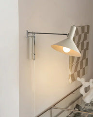 Modern white wall lamp with adjustable arm, plug-in design, mounted above a desk