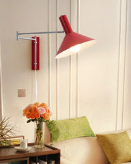 Red plug-in wall lamp with adjustable arm above sofa in modern living room